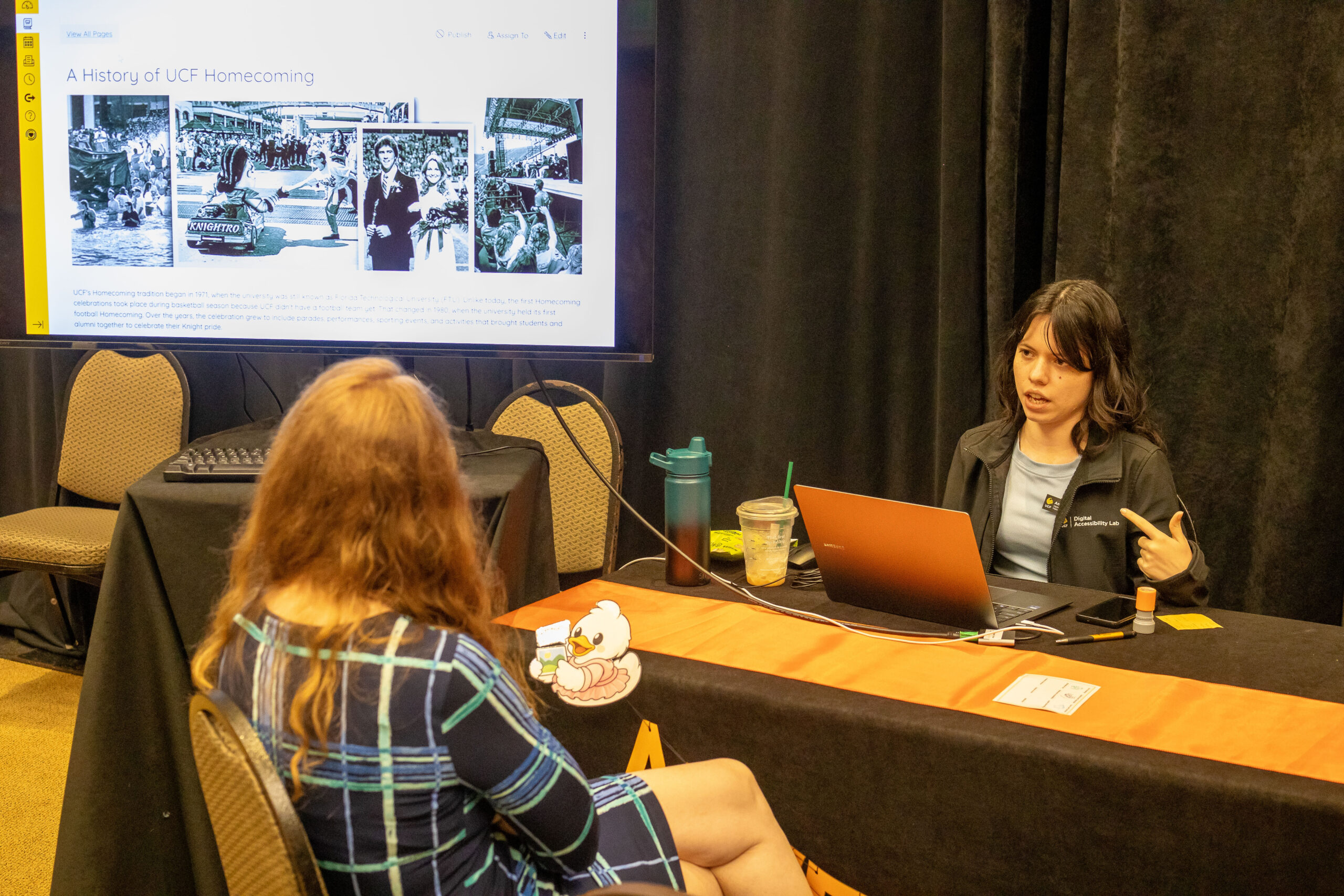 The facilitator for Text Alternative station presenting to an attendee