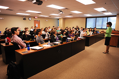 A professor teaching in front of a classroom full of students