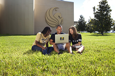 Three students laying outside Welcome Center