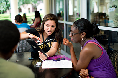 A staff member helping a student with a tablet