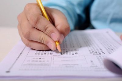 a close up of a hand bubbling in an answer sheet