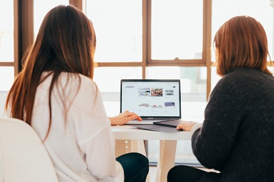 two students on looking at a laptop