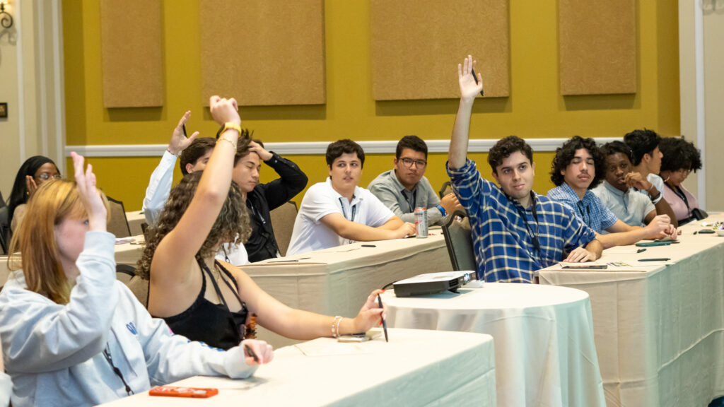 students raising their hands during a workshop