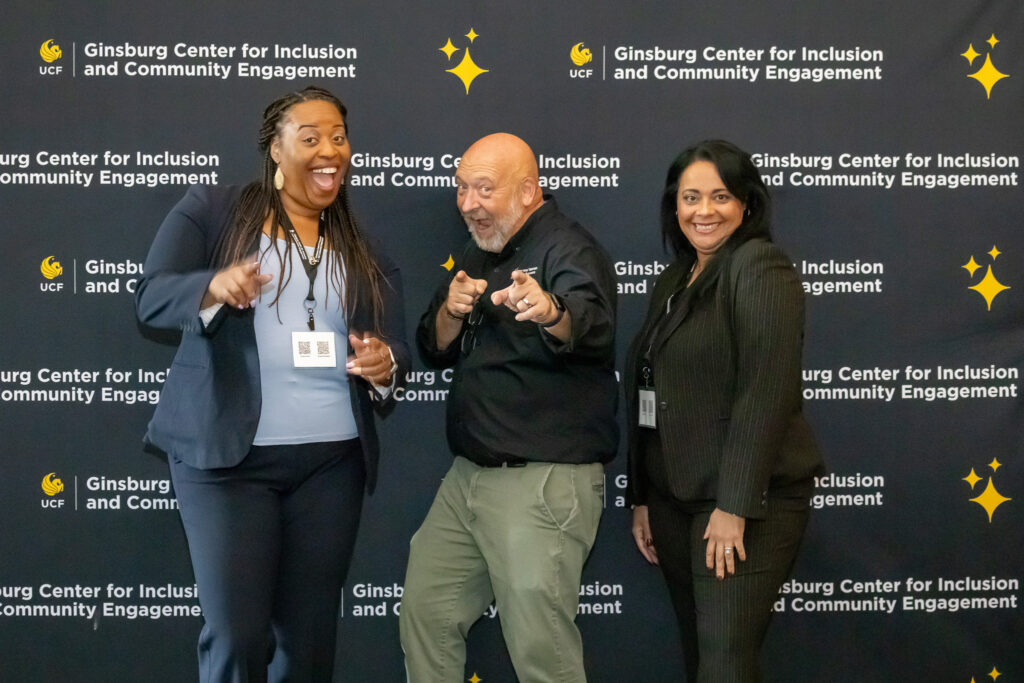 Staff members posing in front of a backdrop