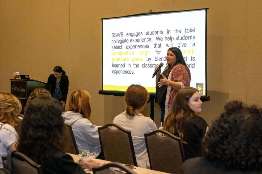 Presenter in front of a screen presenting to students