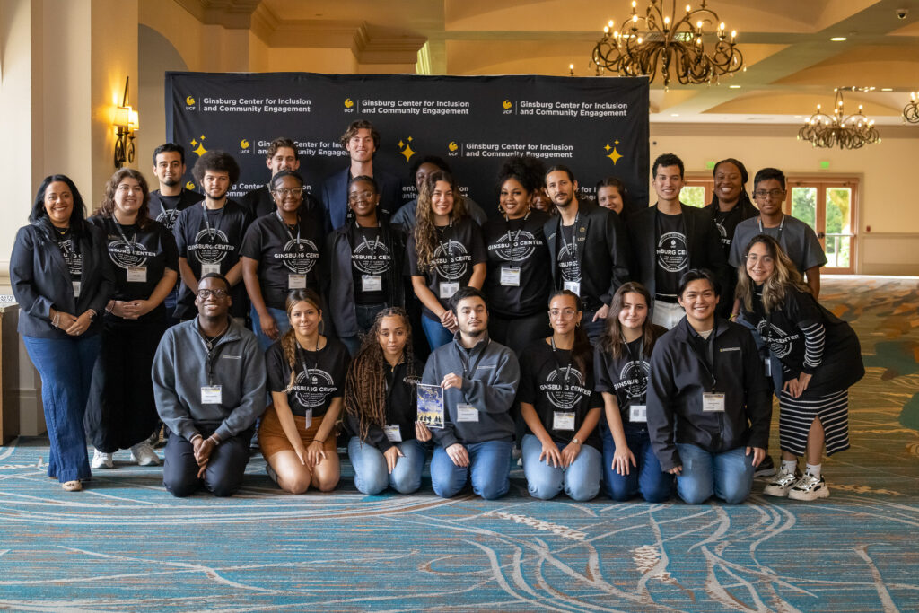 Group of peer mentors, staff and volunteers in front of a backdrop posing