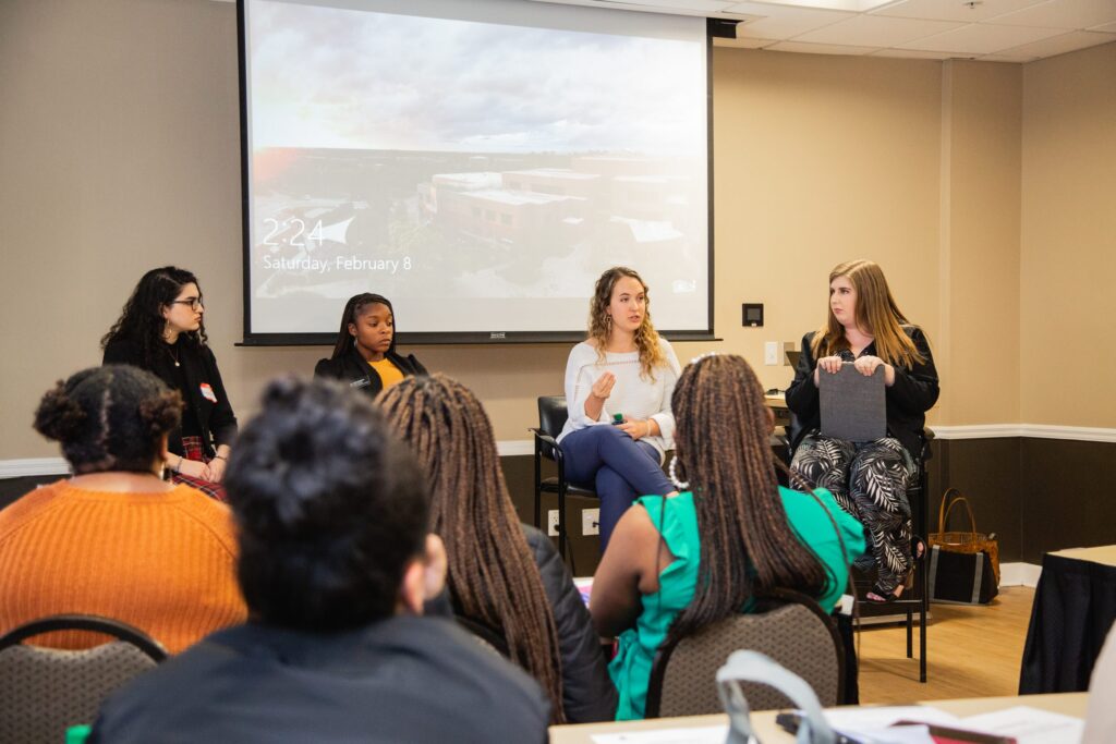 four panelist discuss topics in front of an audience